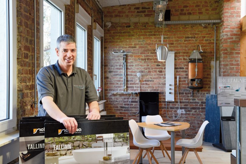 Norbert Mück in seiner Ausstellung mit Fliesen